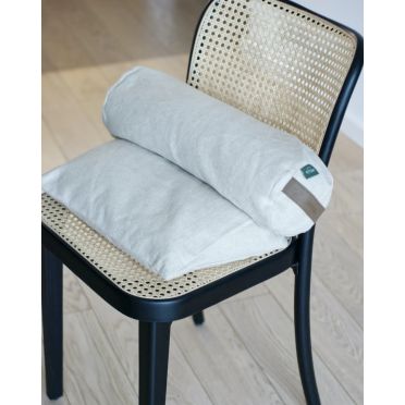 Mały wałek gryczany i poduszka klin na czarnym krześle z plecionym oparciem – elegancki i funkcjonalny zestaw wspierający zdrową postawę podczas siedzenia.